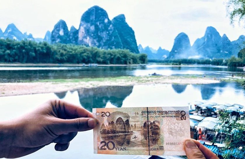 Fare foto al paesaggio naturale raffigurato sul retro delle banconote da 20 yuan nel Villaggio di Xingping